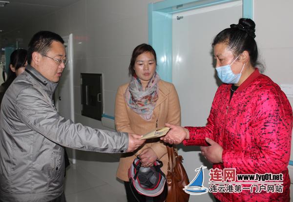 崔艳艳的母亲王女士从城管新海新区大队副教导员崔国华手中接过6000